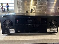 Front view of Pioneer VSX-822-K multi channel receiver showing power button, volume knob, and display with 'TUNER' active.