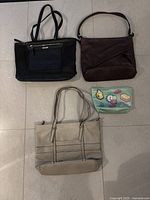 Top down photo of all three purses and a small mint green cosmetic pouch on floor.