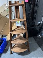 Front view of the 5-tier wooden corner shelf unit showing the five triangular shelves and wooden frame