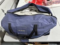 Blue zippered carrying bag with Columbia logo, containing the tent and accessories.