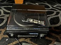 Front and top view of Pioneer linear tracking record player with remote on dust cover and Denon amplifier beneath.