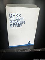 Box labeled 'Desk Clamp Power Strip' showing packaging