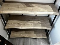 Close-up of three live edge white oak shelves showing natural wood grain and texture with varying shelf depths.