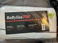 Package of BaByliss Pro extra long cotton towels, unopened, showing brand label and quantity of 12 towels.