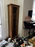 Full front view of slender wooden cabinet in room