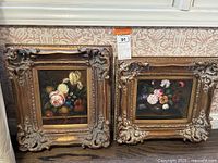 Both framed paintings side by side against patterned wallpaper