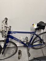 Full view of blue Trek road bike with white water bottle mounted on frame and black saddlebag under seat.