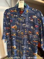 Front view of the blue short-sleeved Aloha shirt with Cars 2 pattern including cars and world landmarks.