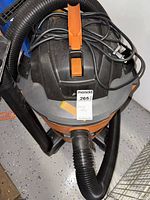 Top view of the Rigid shop vacuum, showing the power switch, handle, and attached coiled power cord.