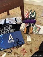 Overview of entire lot showing umbrellas, ponchos, and commemorative bags arranged on carpet