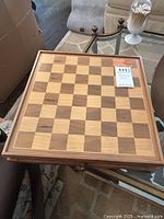 Wooden chess board viewed from above, showing checkerboard pattern and wooden frame
