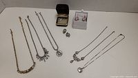 Overview of all jewelry items including necklaces and rose-colored CZ earrings.