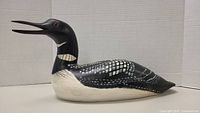 Side view of hand painted Common Loon sculpture showing the body and feather detailing.
