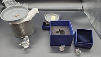 Three Swarovski crystal animal figurines displayed alongside original blue boxes and packaging, showing the overall lot and contents.