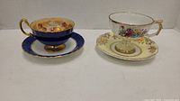 Pairs of three teacups and saucers: cobalt blue Aynsley set, unmarked Japanese cup, and Colclough saucer