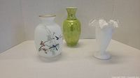 Photo showing all three vases: white frosted glass painted vase, green porcelain vase, and white glass fluted vase