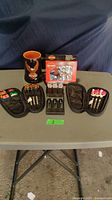 Full lot view showing Harley Davidson mug, two card decks, and three dart sets with cases and extra flights.