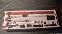 Full view of Bushnell telescope and tripod in original packaging showing components and accessories arranged in foam.