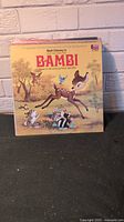 Photo of vintage Walt Disney's Bambi vinyl record album cover with illustrated cover art of Bambi and friends in the forest.