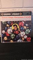 Close-up of 'Lanza Sings Christmas Carols' vinyl record cover showing festive ornaments and Mario Lanza's photo.