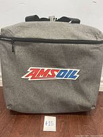 Front view showing AMSOIL logo on cooler front panel, gray fabric with zippered compartment.