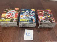 Three sealed Battle B-Daman bootleg toy boxes arranged side by side on a wood floor.