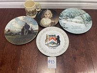 Lot overview showing five collectible plates and one ceramic cup on floor with lot card #43
