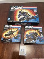 Photo showing all three sealed GI Joe construction sets: Ninja Commando 4x4, Cobra FANG, and Cobra FERRET on table.