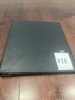 Black binder holding the card set with handwritten label '#18' on front cover