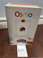 Box with Osmo branding showing the front with image of the base and tangram shapes