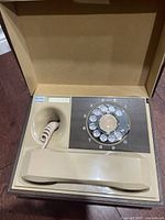 Vintage Deco-Tel rotary dial telephone in faux wood case, showing handset and rotary dial.