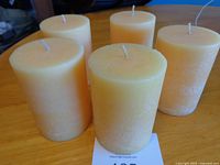 Five peach pillar candles standing upright on table