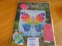 Front view of sealed Butterfly Quilt pattern booklet with stickers