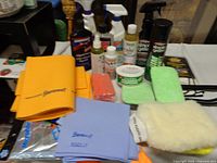 Overview of all items on table including ShamWow cloths, bottles, sponges and mitt