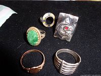 All five rings laid out on black surface