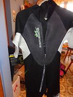 Full front view of wetsuit hanging, tag visible