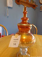 Full view of amber glass pedestal jar with lid