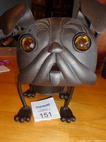 Front view showing pug head, eyes, feet and tag