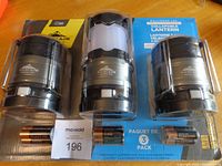Front view of sealed package showing three lanterns and included batteries