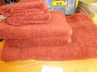 Stacked rust⁄spice towels showing bath, hand and face cloths