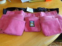 Front view showing three pink suede pouches and Power Fist logo