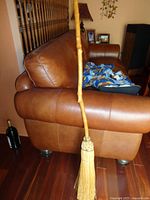 Full view of rustic broom leaning against couch