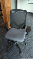 Front-side view of the office chair showing padded seat, mesh backrest, and armrests.