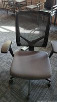 Front view of black office chair showing mesh back and padded seat.