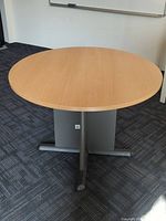 Top view of the round wooden tabletop showing light wood grain surface.