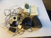 Lot items arranged together showing all speakers and webcams with cables.