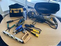 Overview of assorted hand tools including wire strippers, screwdrivers, crimpers, saw, spirit level, Dewalt bags, battery charger and air duster.