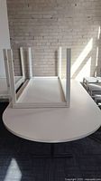 Photo showing the underside and legs of the white table with curved end.