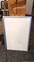 Front view of white board with white dry erase surface and silver aluminum frame.