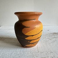 Photo showing front view of the Royal Haeger vase with orange peel lava glaze and crackle detailing on an orange brown background.